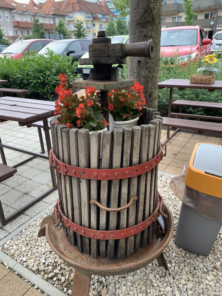 Old wooden wine press used as a flower planter in Hévíz town